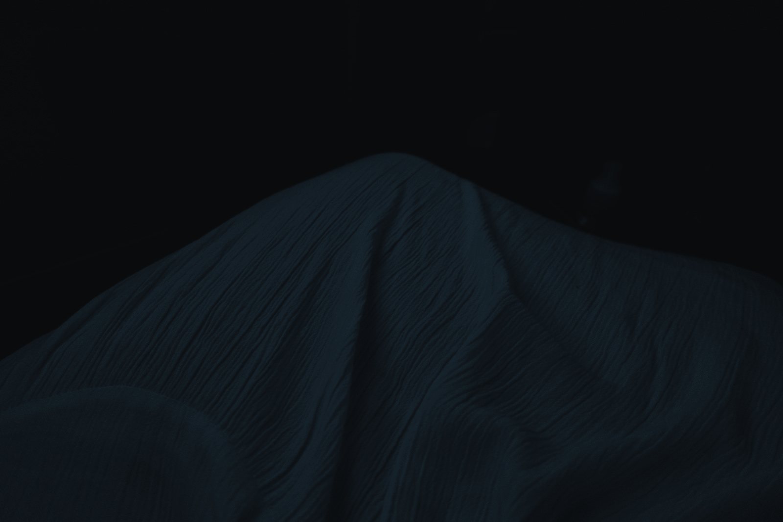 Soft fabric draped in near darkness