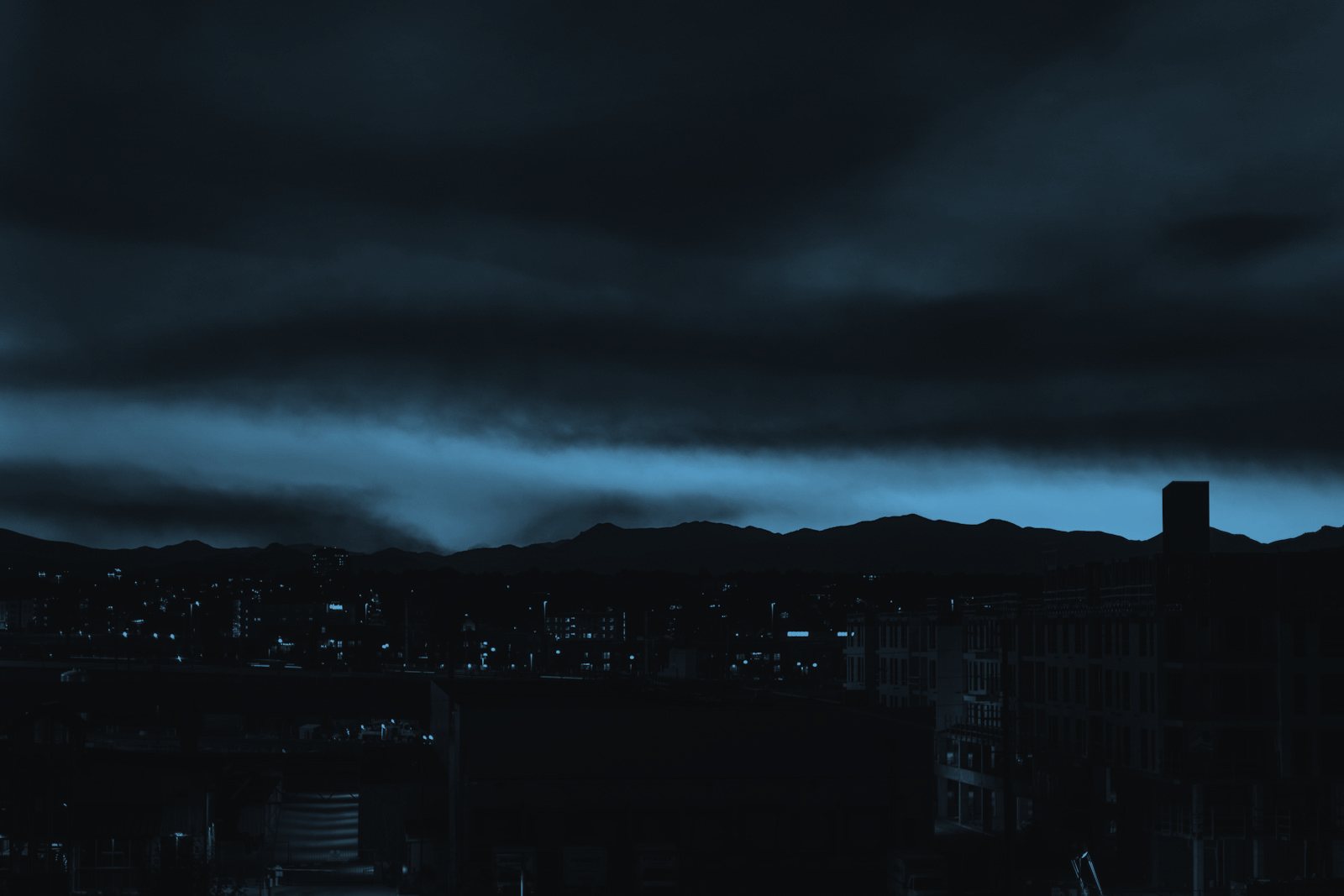The Denver skyline at night under heavy cloud