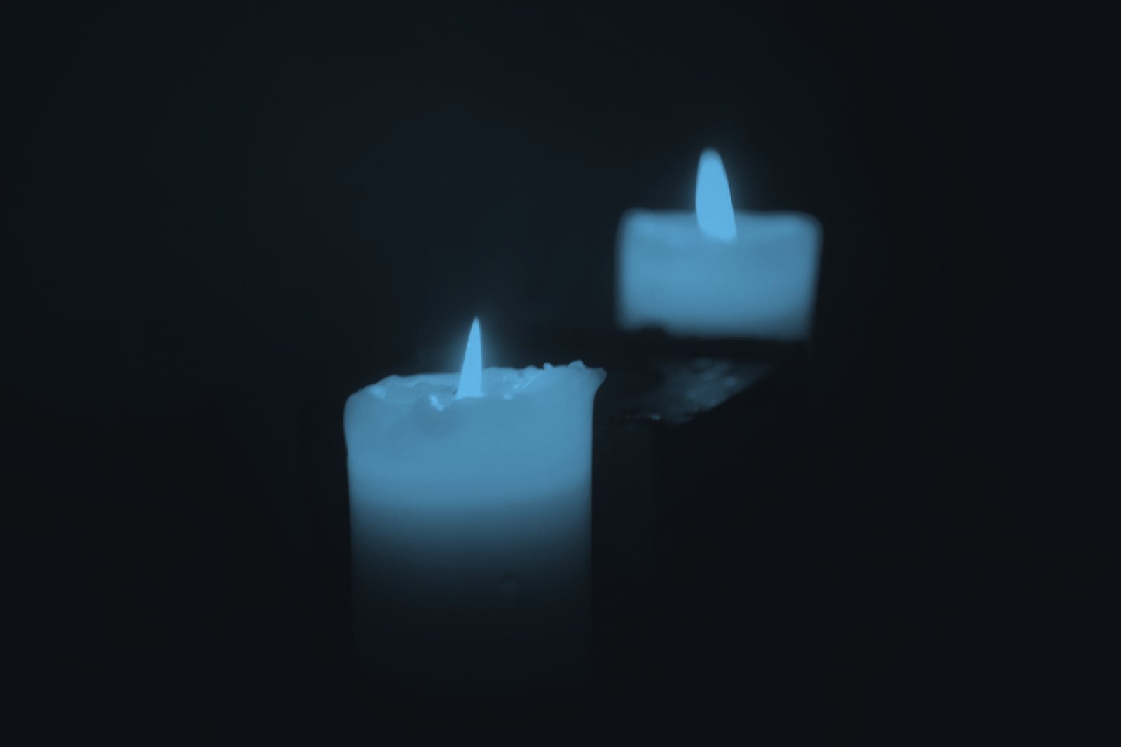 Two candles burning in the dark